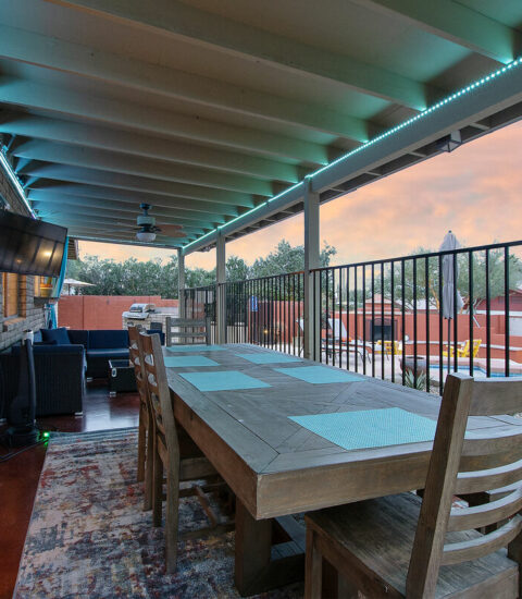 Outdoor entertainment area with smart television and LED lighting.