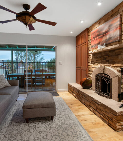 Living area with wood burning fireplace. Television and business center located in cabinet.