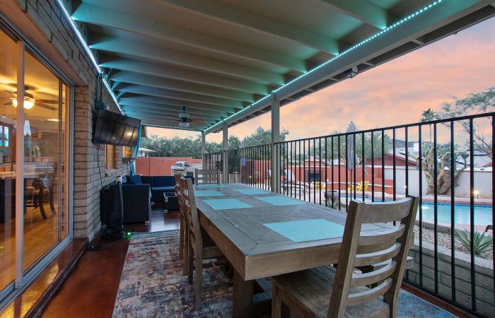 Outdoor entertainment area with smart television and LED lighting.