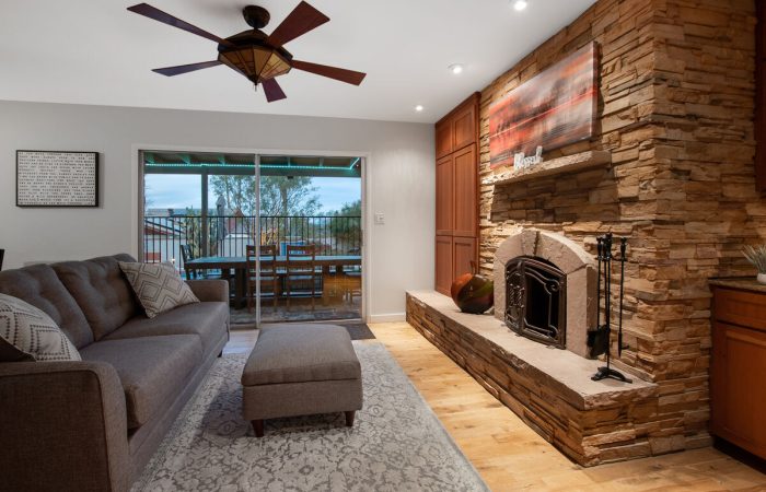 Living area with wood burning fireplace. Television and business center located in cabinet.